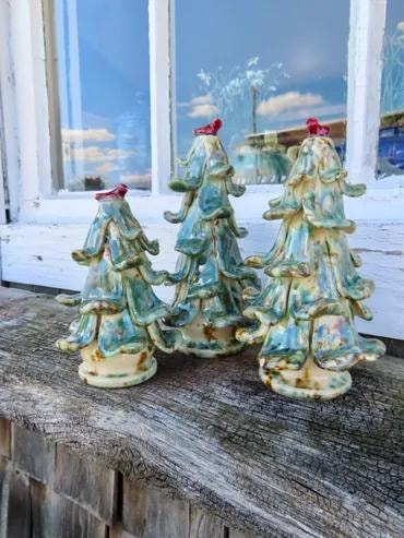 Three aqua glazed ceramic Christmas trees with red cardinal toppers