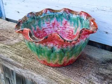 Ruffled ceramic bowl with vibrant pink, green, and red glaze