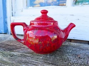 Vibrant red glazed ceramic teapot with iridescent finish