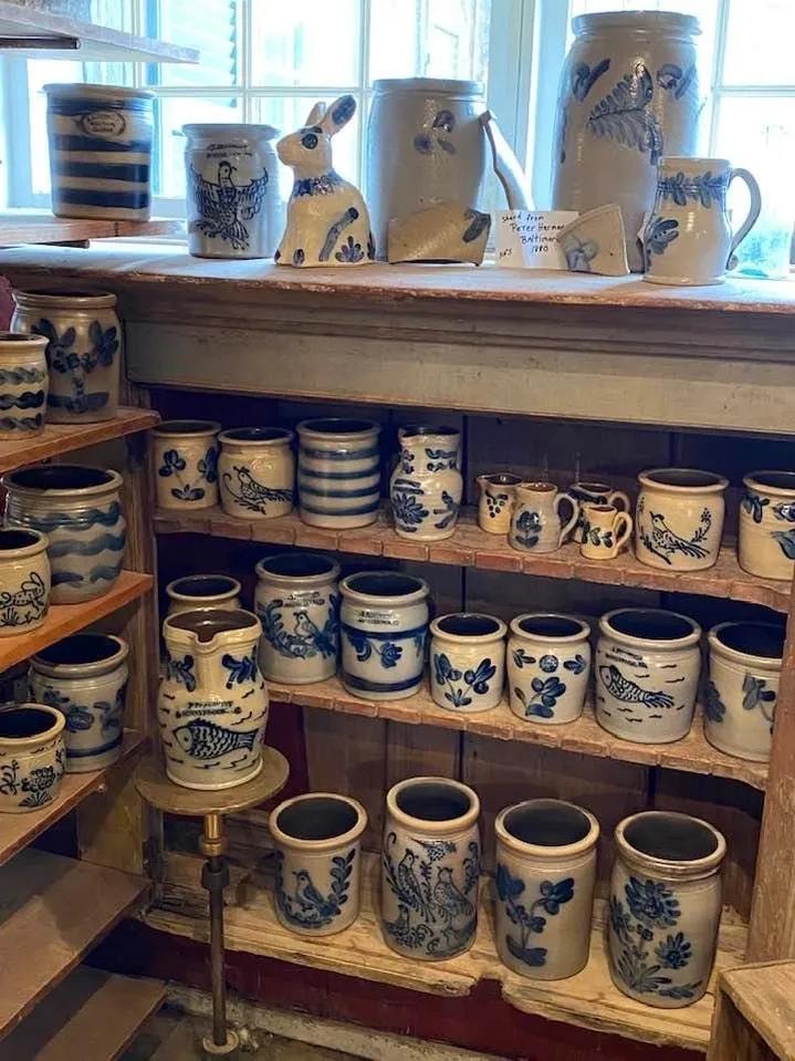 Blue and white stoneware crocks and jugs on wooden shelves